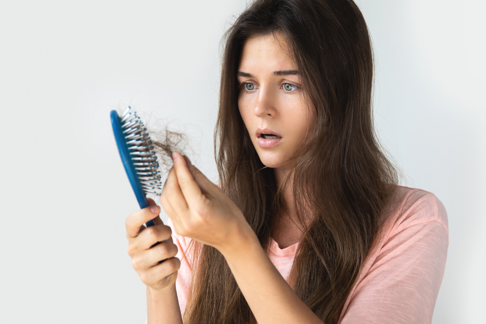 Concerned woman noticing hair loss, indicating the need for medical spa hair restoration.
